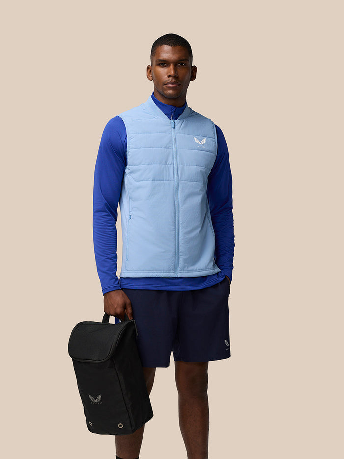Male model in blue athletic wear carries a black boot bag by its top handle
