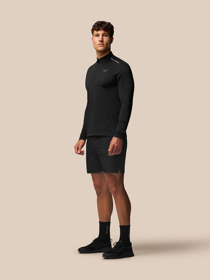 Male model in black Apex Training Shorts with zipped side pockets and reflective branding on the thigh
