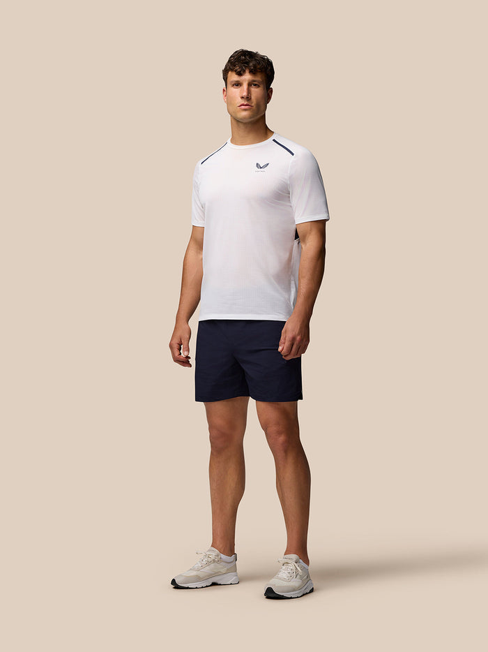 Male model in white top and navy Apex Training Shorts with Castore branding
