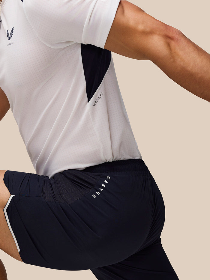 Male model wearing navy Apex Training Shorts with side pockets and Castore branding