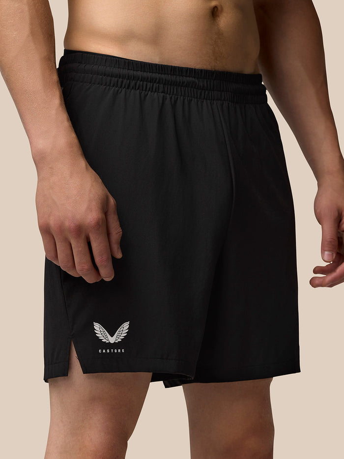 Close up of black Adapt Training 6 Shorts with elastic waistband and Castore wing logo at the hem.