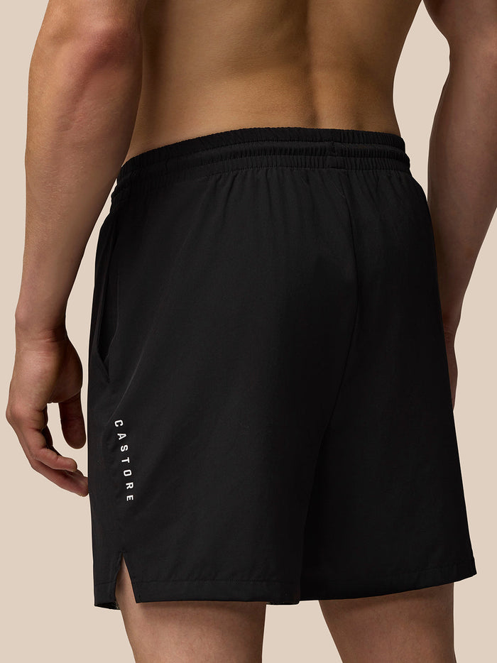 Back view of a man wearing black Adapt Training 6in shorts with an elastic waistband and side pocket