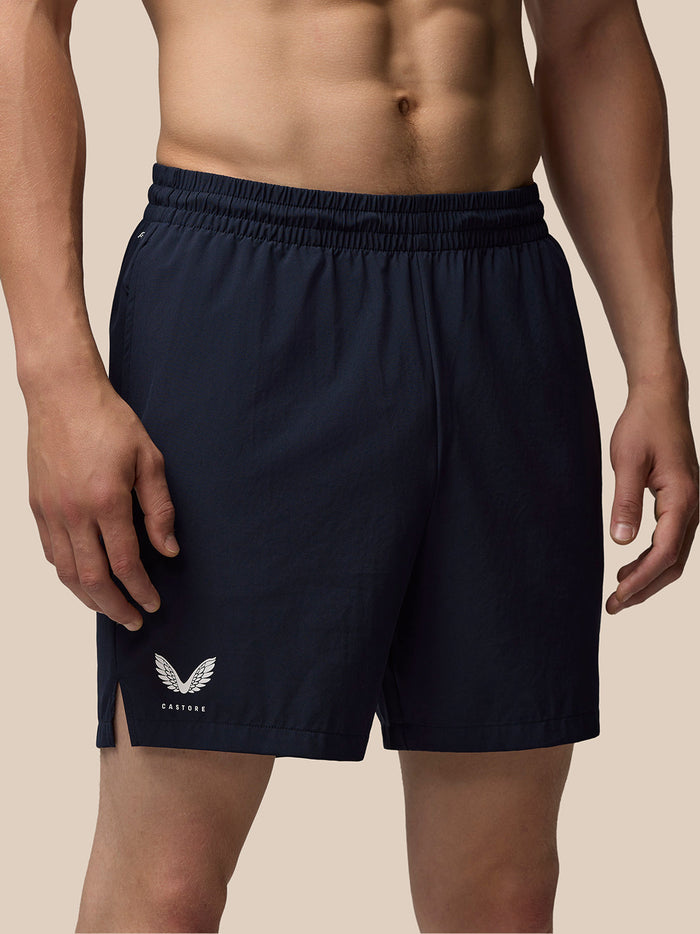 Male model in navy Adapt Training 7 shorts with a white Castore logo on the thigh.