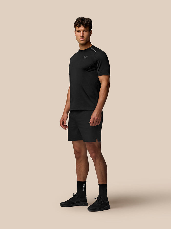 Full-body shot of a male model wearing Apex Training T-Shirt in black with matching shorts and sneakers