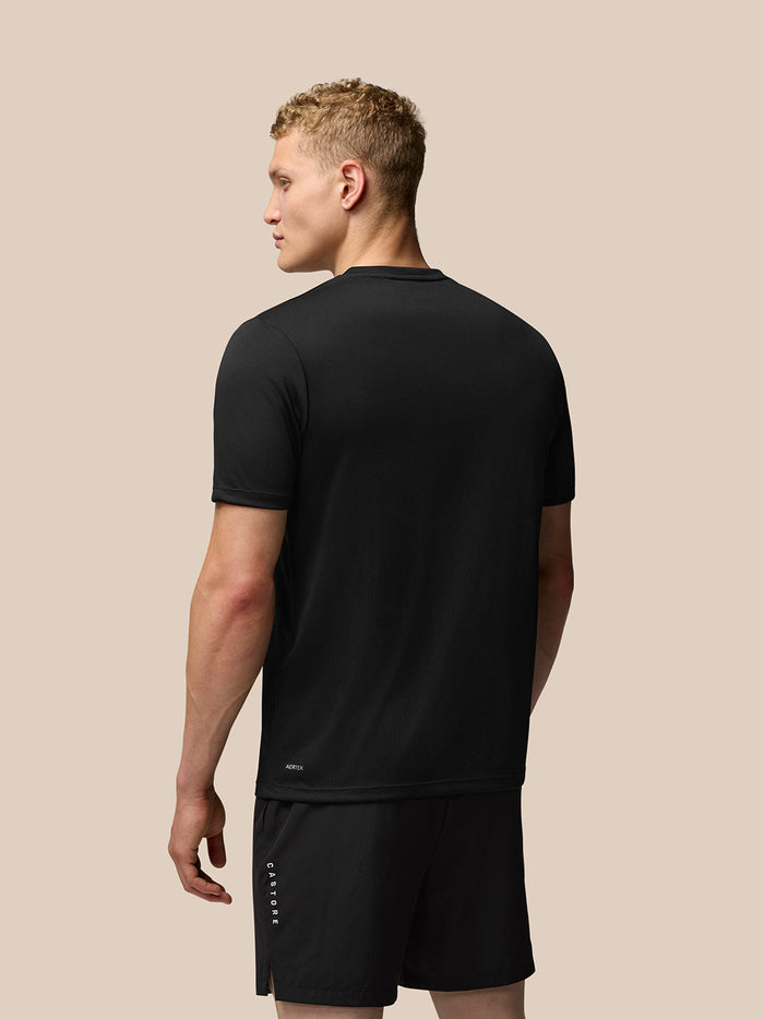 Profile view of a man wearing black Adapt Training T-Shirt with Castore wings graphic on chest