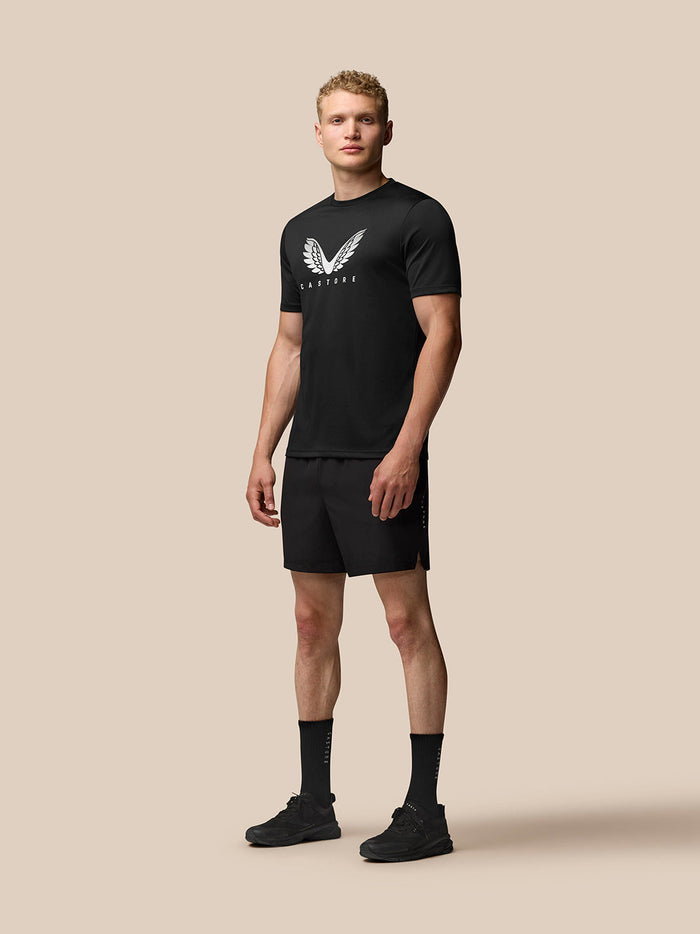 Male model wearing black Adapt Short Sleeve Graphic T-Shirt with white Castore wings on chest.
