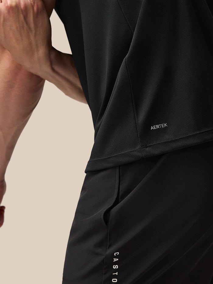 Close-up of the lower back hem showing AERTEK branding on black Adapt Training T-Shirt
