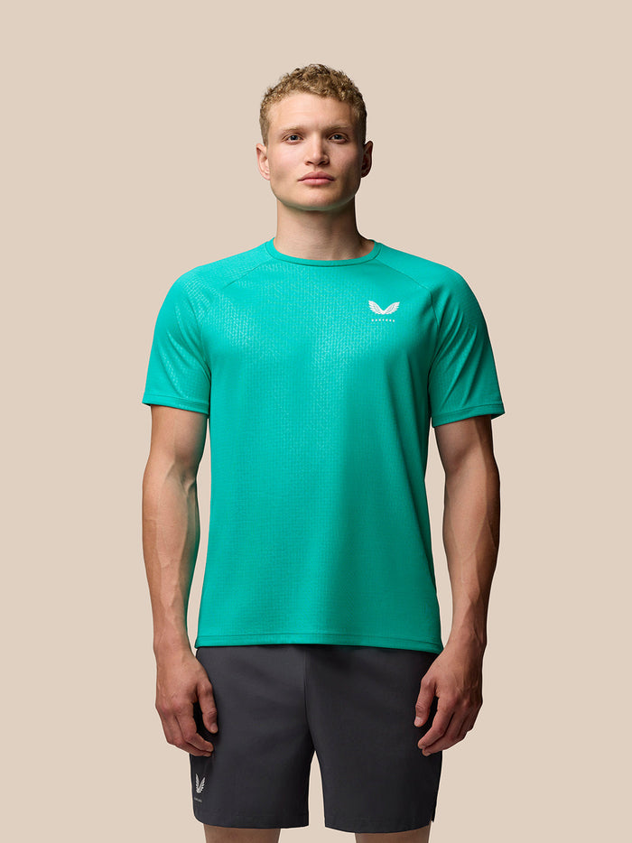 Male model wearing Adapt Training T Shirt Dark Aqua with geometric print and raglan sleeves.