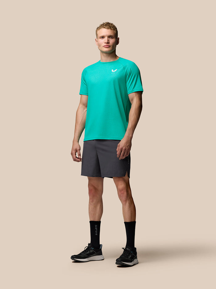 Male model wearing Adapt Training T Shirt in dark aqua with a subtle geometric pattern and Castore logo on the left chest