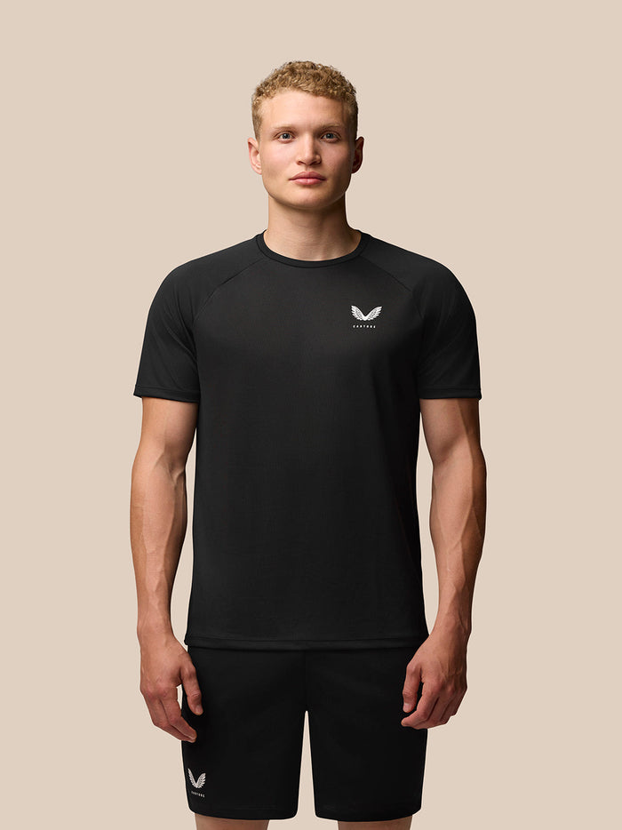 Front view of a man wearing black Adapt Short Sleeve T-Shirt with Castore logo on the chest.