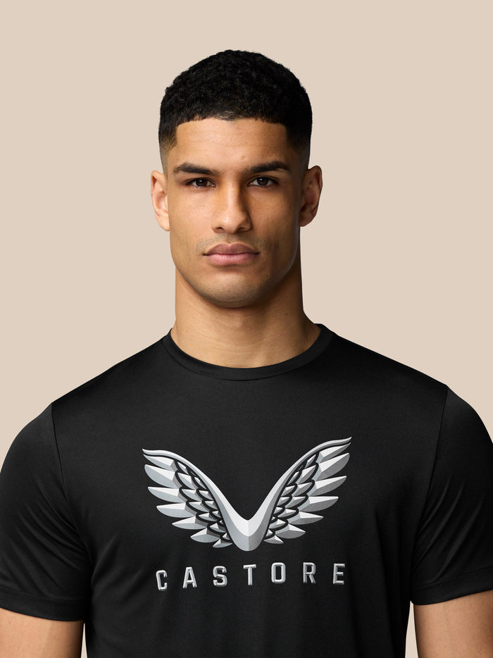 Male model wearing black short sleeve graphic T-shirt with a white wing logo on the chest