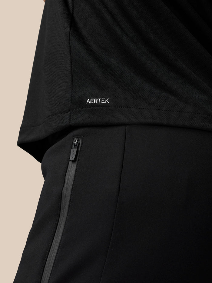 Close-up of black graphic T-shirt showing AERTEK branding at the lower back hem