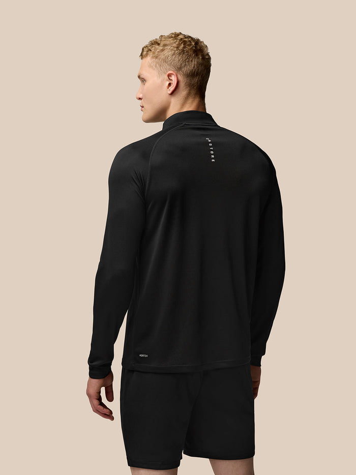 Male model in black Adapt Training Top shown at a side/back angle with Castore branding on left chest and upper back