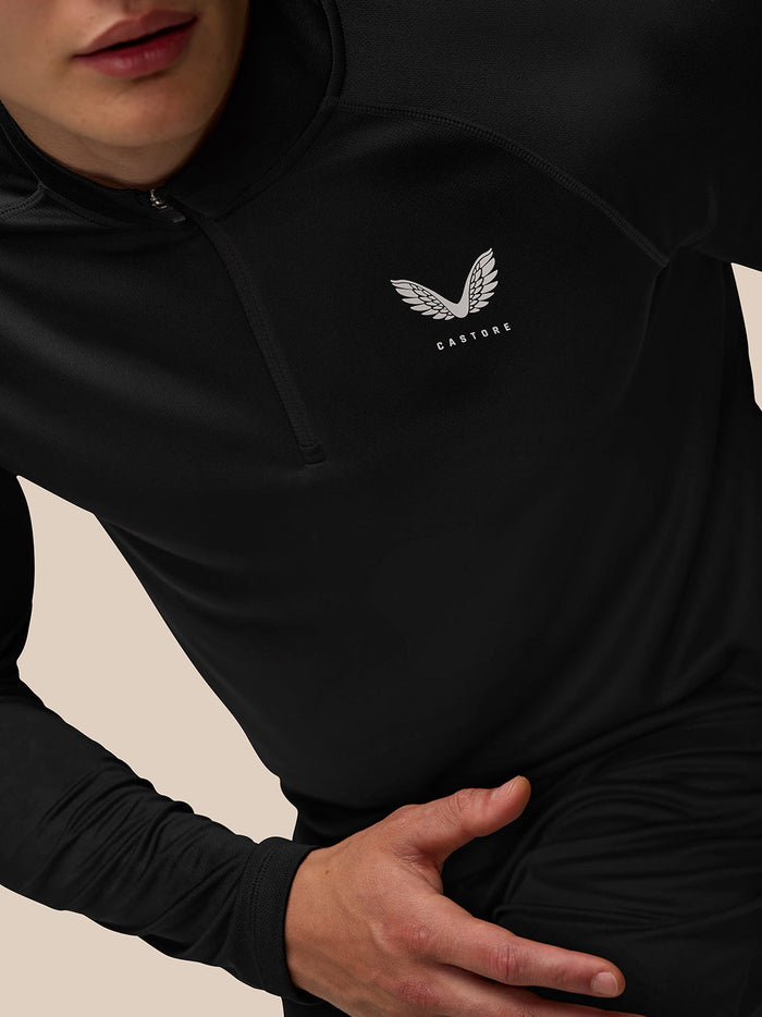 Close-up of black Adapt Training Top with white Castore wing logo on left chest