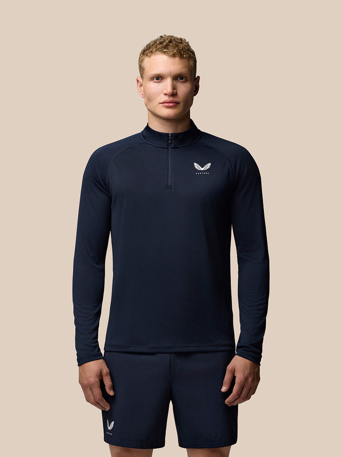 Front view of midnight navy Adapt Training Quarter Zip Top with stand collar and Castore branding on chest