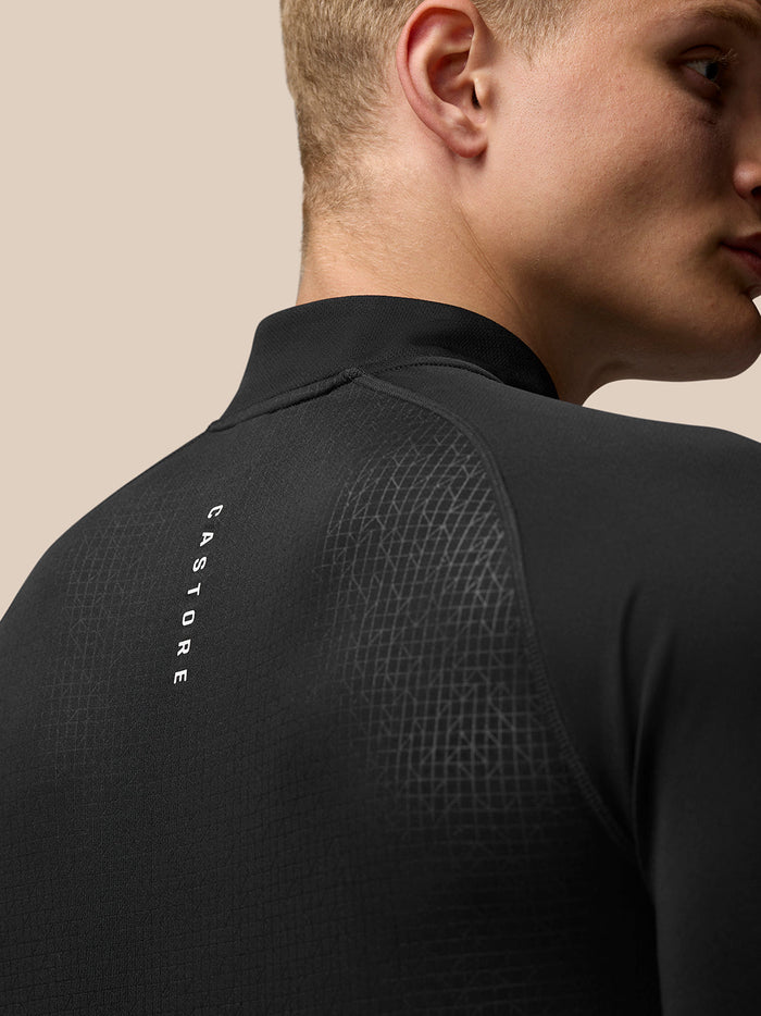 Back view of black Adapt Print Quarter Zip Top with vertical Castore branding along the back and Aertek branding at the lower back