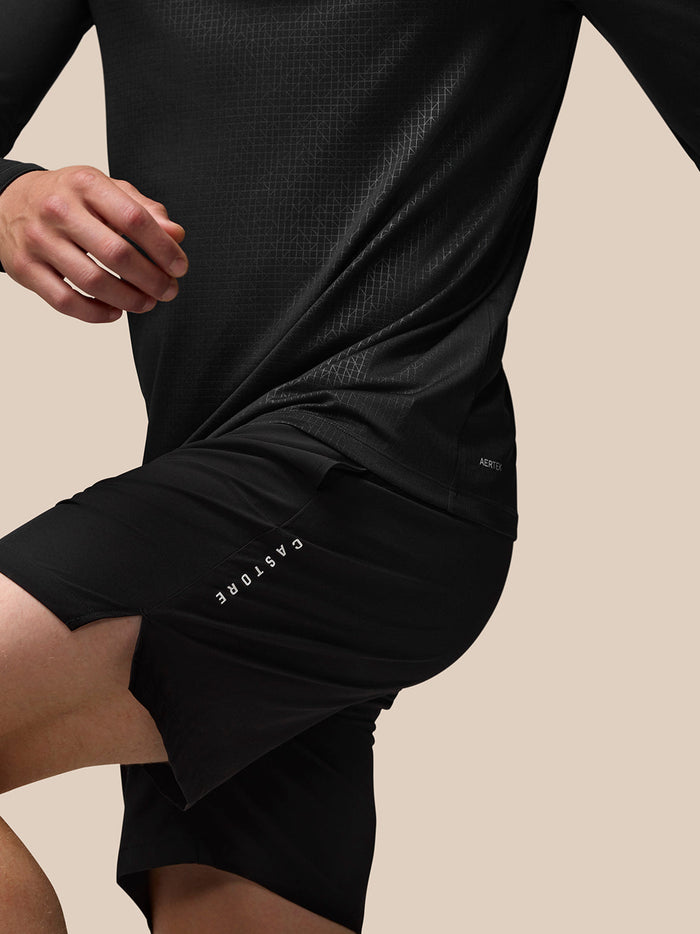 Back view of black Adapt top with shorts showing the lower back Aertek branding and Castore branding on the shorts with a subtle geometric pattern