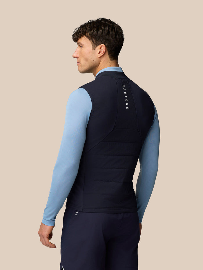 Back view of a man wearing navy Apex Training Gilet with Castore branding on the upper back.