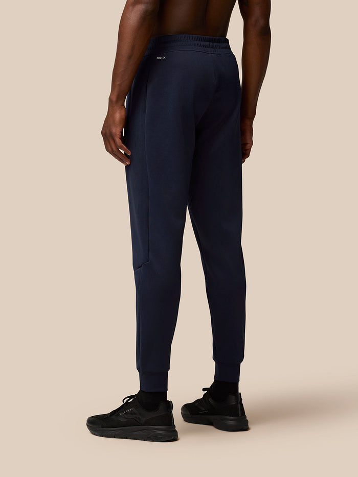 Back view of navy Flex Lifestyle Joggers showing an elastic waistband with Protek branding and a zipped hip pocket