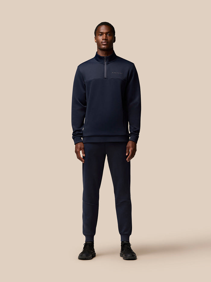 Male model in navy Flex Lifestyle Joggers with a matching top and Castore branding on the left thigh