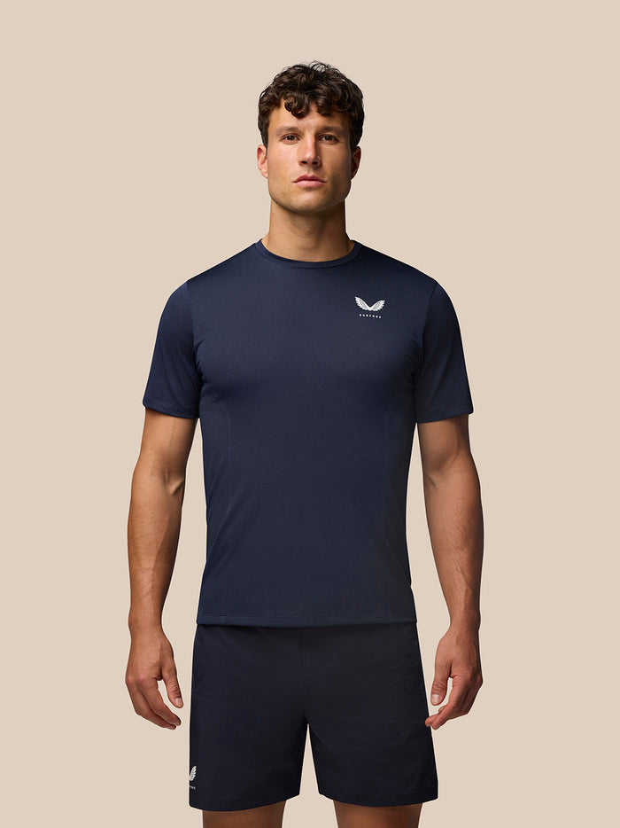 Man wearing midnight navy Apex Training T Shirt with crew neck and raglan sleeves; Castore logo on left chest