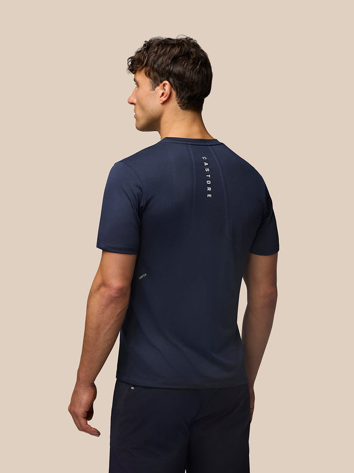 Back view of a man in navy Apex Training T Shirt with a vertical Castore branding down the back