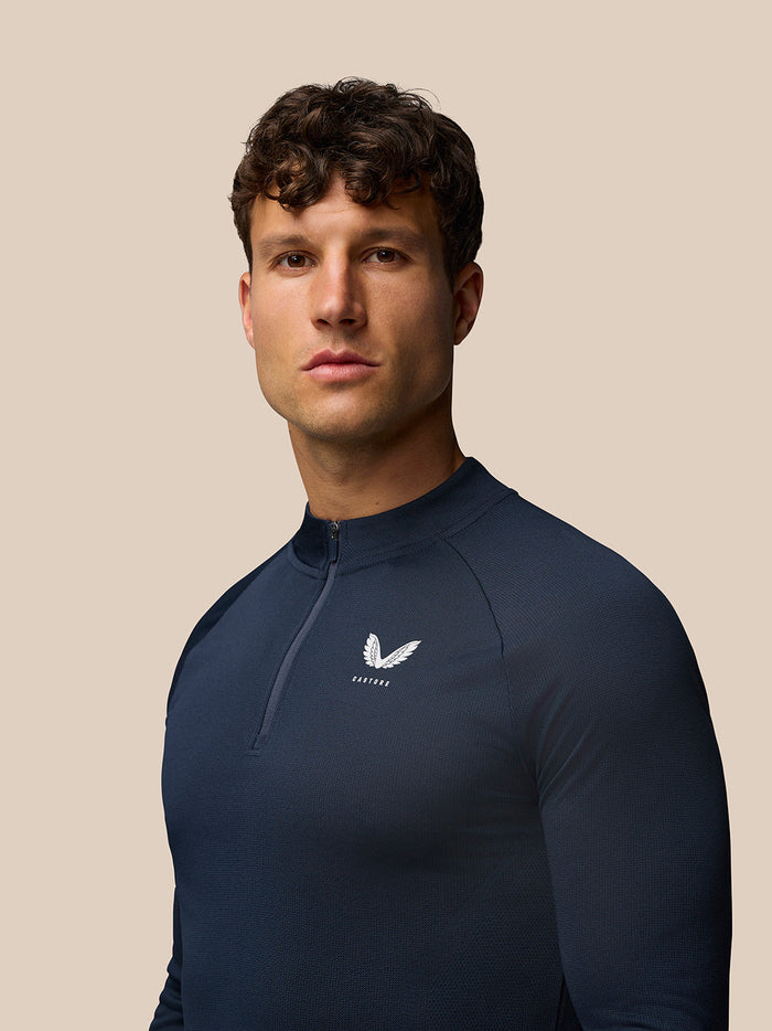 Model wearing navy Apex Training Quarter Zip Top with stand collar and left chest logo
