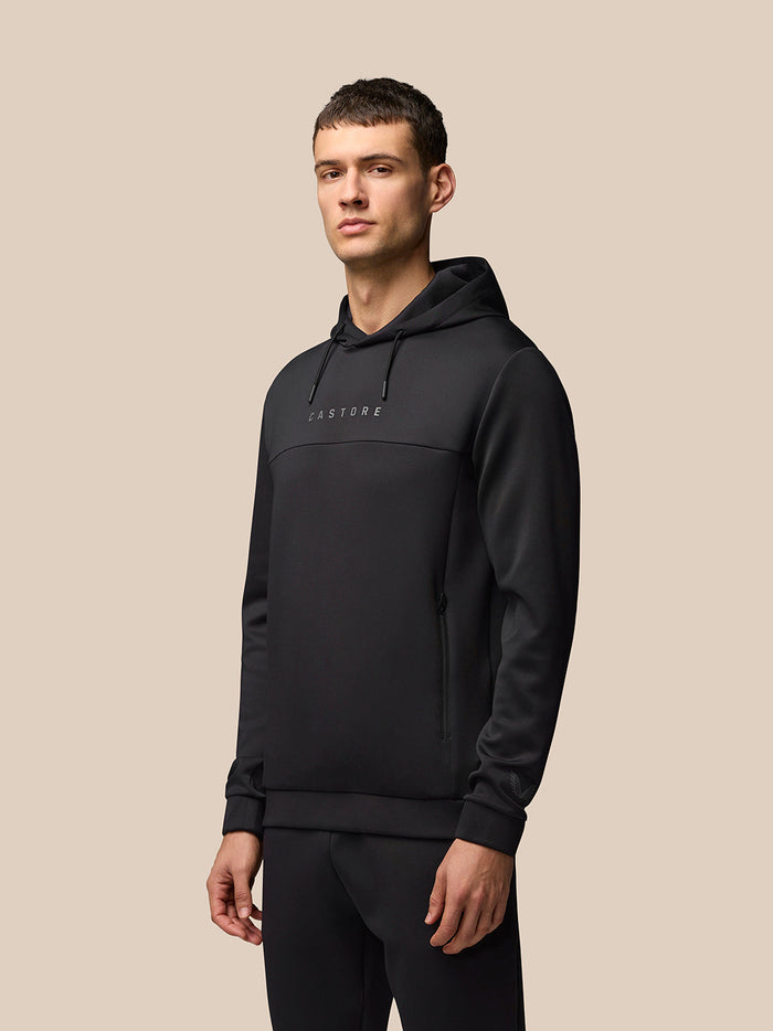 Male model in black Flex Hoodie front view with hood and Castore branding on the chest