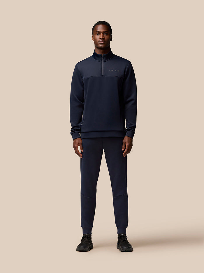 Model wearing navy Flex Lifestyle Quarter Zip top with Protek finish and zip pockets