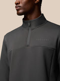 Close up of a man wearing a charcoal Flex Lifestyle 1/4 Zip top focusing on the zip collar and Castore logo on the chest.