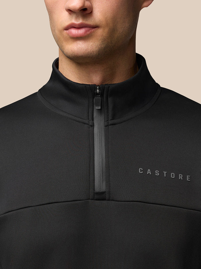 Close up of black Flex Lifestyle quarter zip neck showing zipper detail and Castore branding on the chest