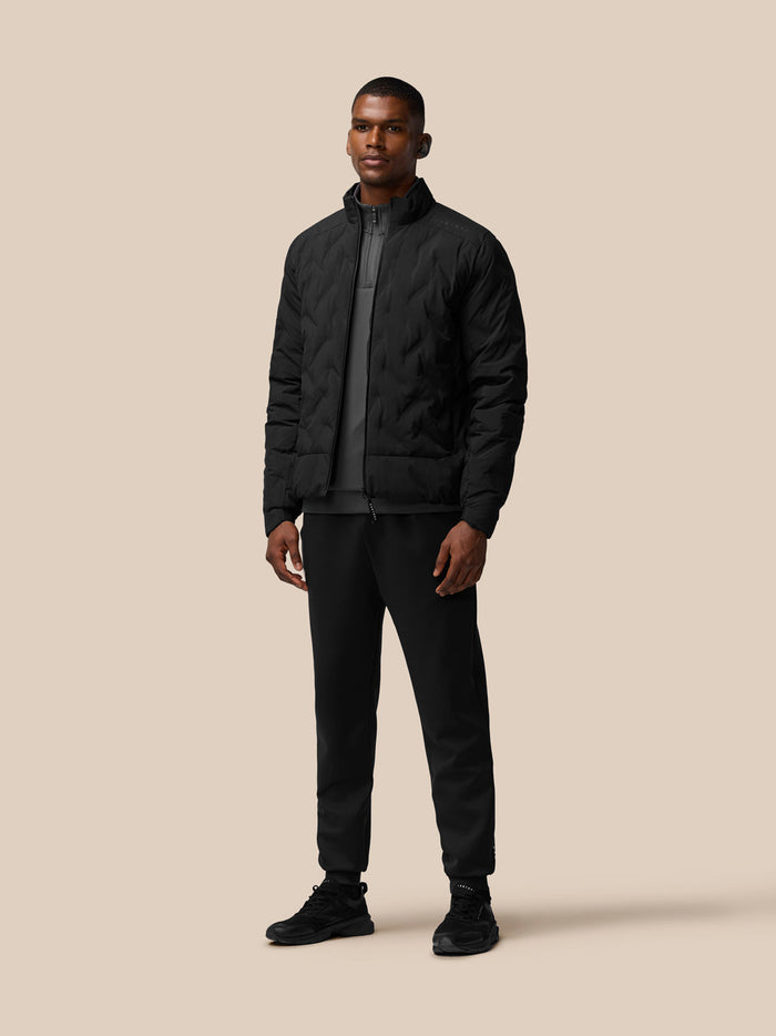 Front view of a man in a black padded jacket with a high collar and zip front.
