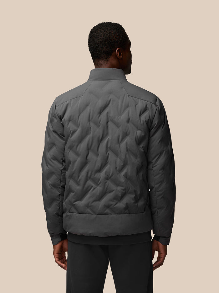 Back view of charcoal quilted jacket with diamond stitch pattern on a model