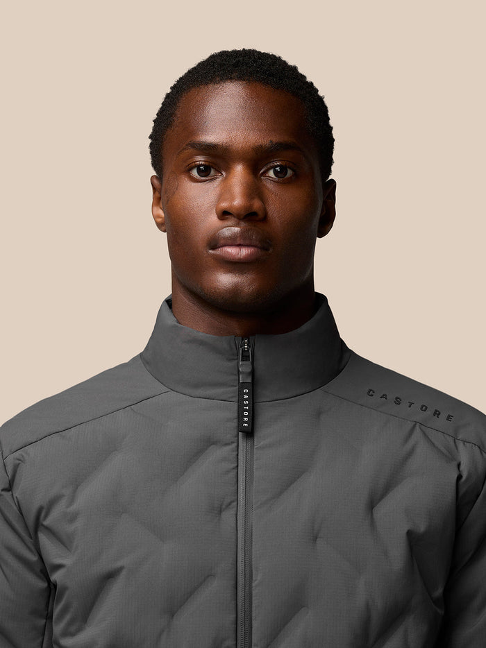 Close-up of model wearing charcoal Quilts Lifestyle Jacket focusing on high collar and front zipper