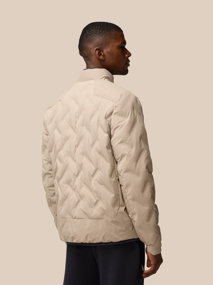 Back view of beige Mushroom padded jacket on a man, showing quilted pattern