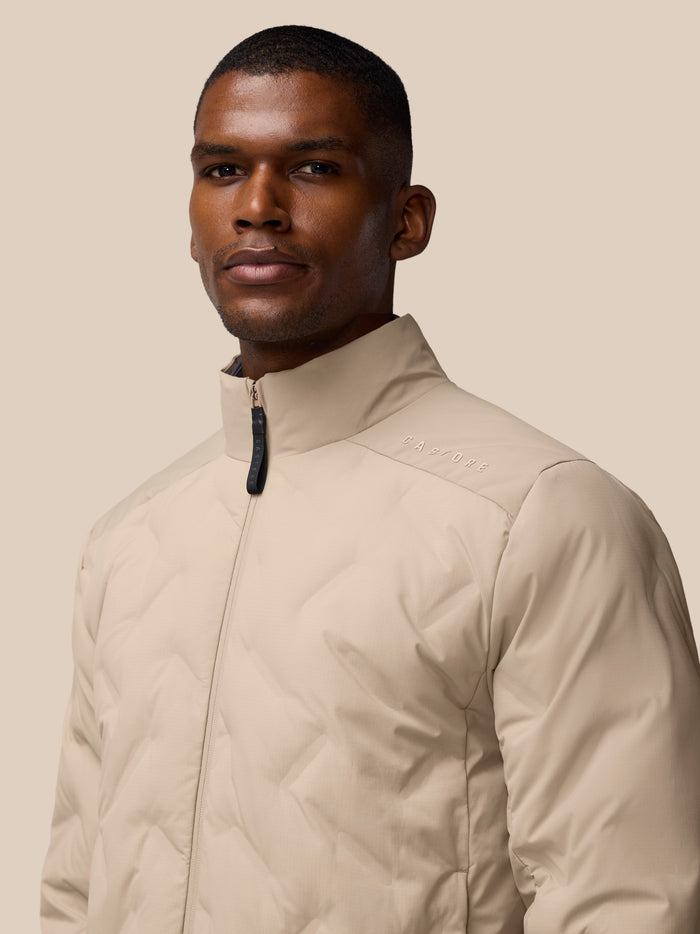 Male model wearing mushroom padded jacket with stand-up collar and front zipper.