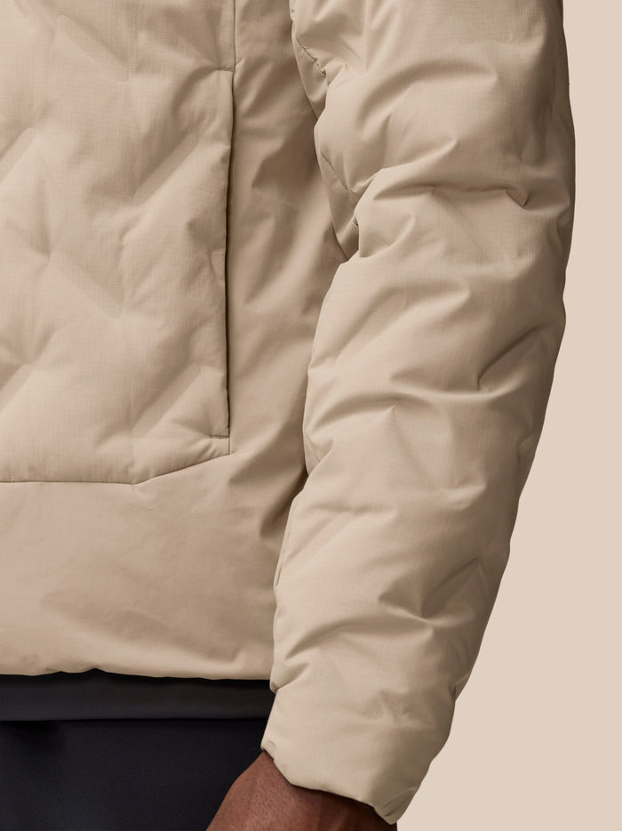 Close up of Mushroom colored padded jacket fabric with stitched panels and seams.