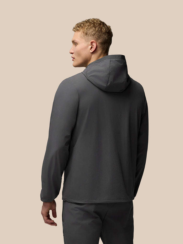 Back view of charcoal Lightweight Flex Jacket on model showing hood and streamlined silhouette.