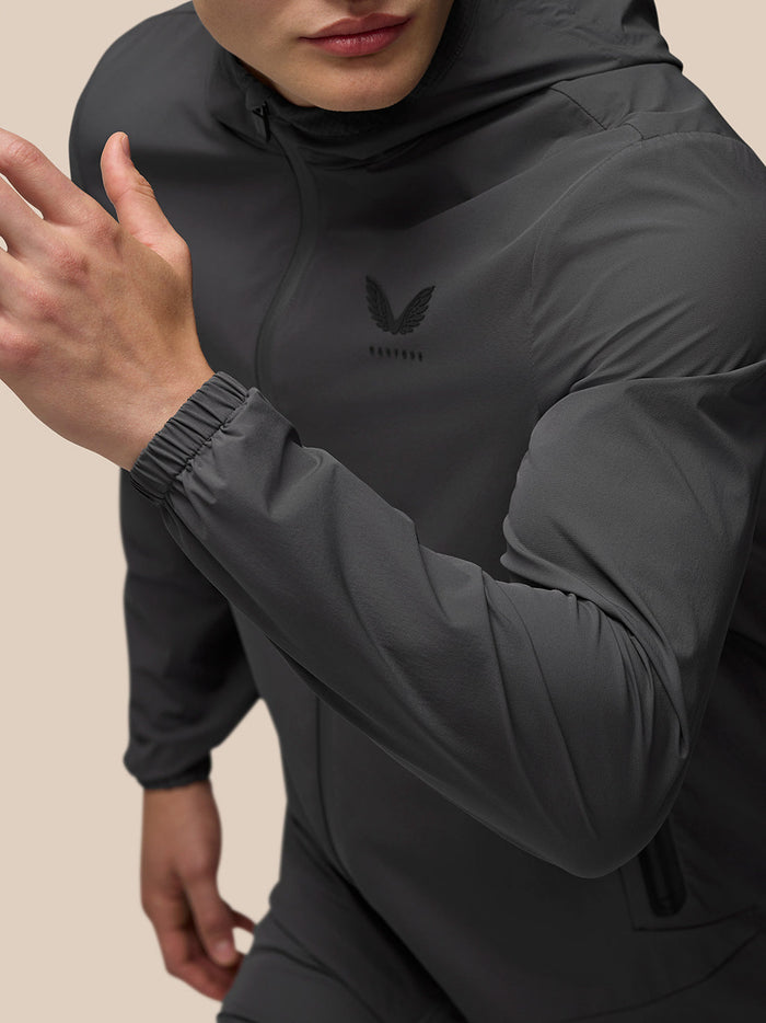 Close up of charcoal Lightweight Flex Jacket highlighting chest branding and cuffed sleeve.