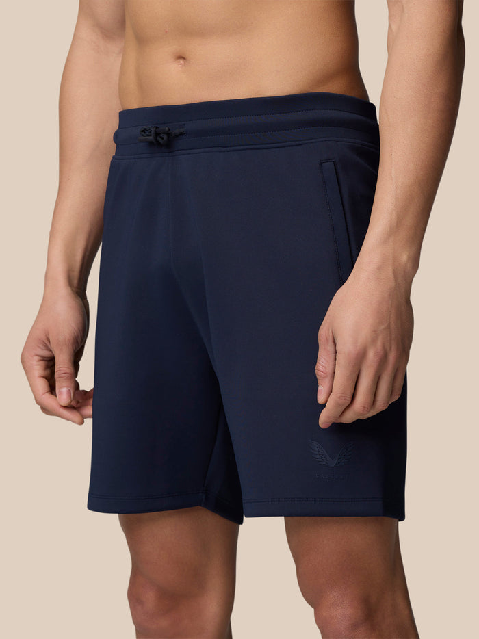 Male model wearing midnight navy Flex Lifestyle Shorts with no side seams and logo on the left leg