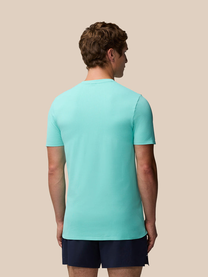 Back view of a man wearing the light aqua Zone Training T-Shirt on a beige background