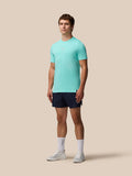Model wearing Zone Training T-Shirt in light aqua with navy shorts, standing against a beige background.