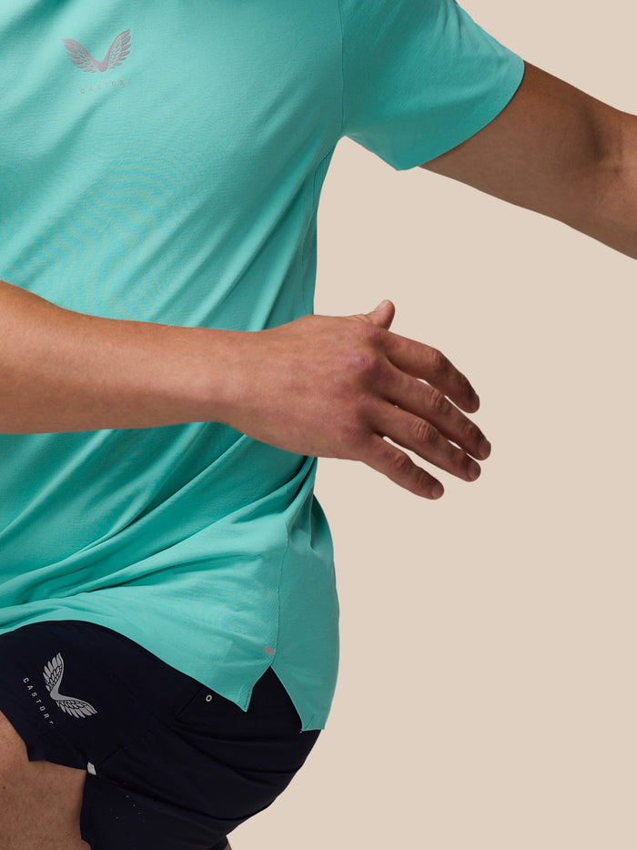 Close-up of torso in light aqua Zone Training T-Shirt, showing chest logo and curved hem.