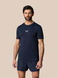 Man wearing Midnight Navy Zone Training T-Shirt with small chest logo against a beige backdrop