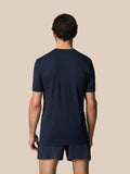 Back view of a man in Midnight Navy Zone Training T-Shirt and matching shorts on a beige background