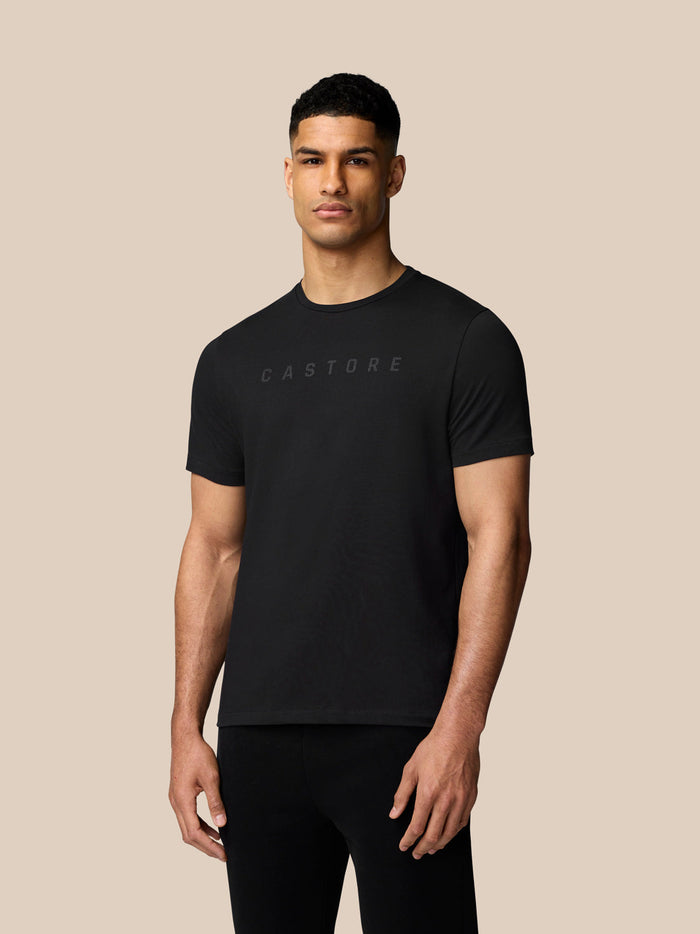 Male model wearing black graphic T-shirt with Castore logo on chest