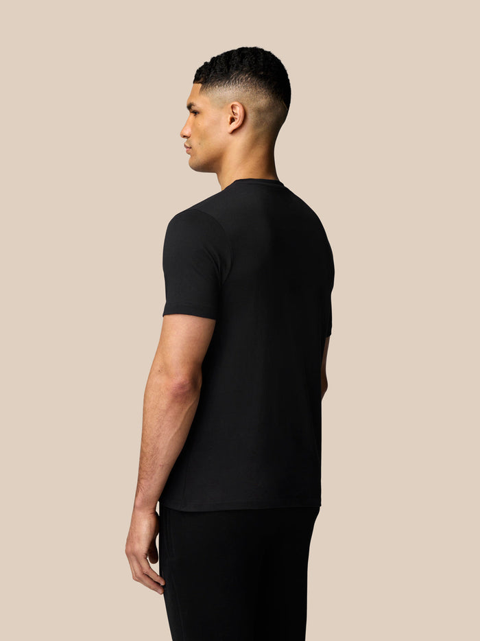 Male model in black short sleeve graphic T-shirt shown in left side profile