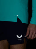 Close-up of teal Zone Training 1/4 Zip Top fabric with reflective hem logo and curved hem detail