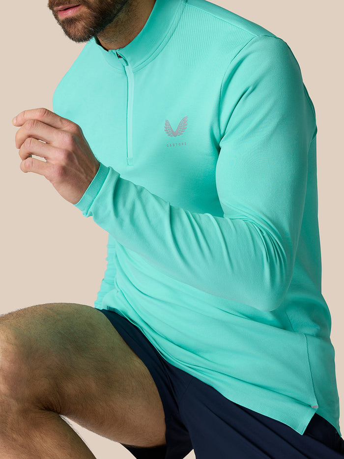 Model wearing Zone Training quarter-zip top in Light Aqua with high neck and chest logo.
