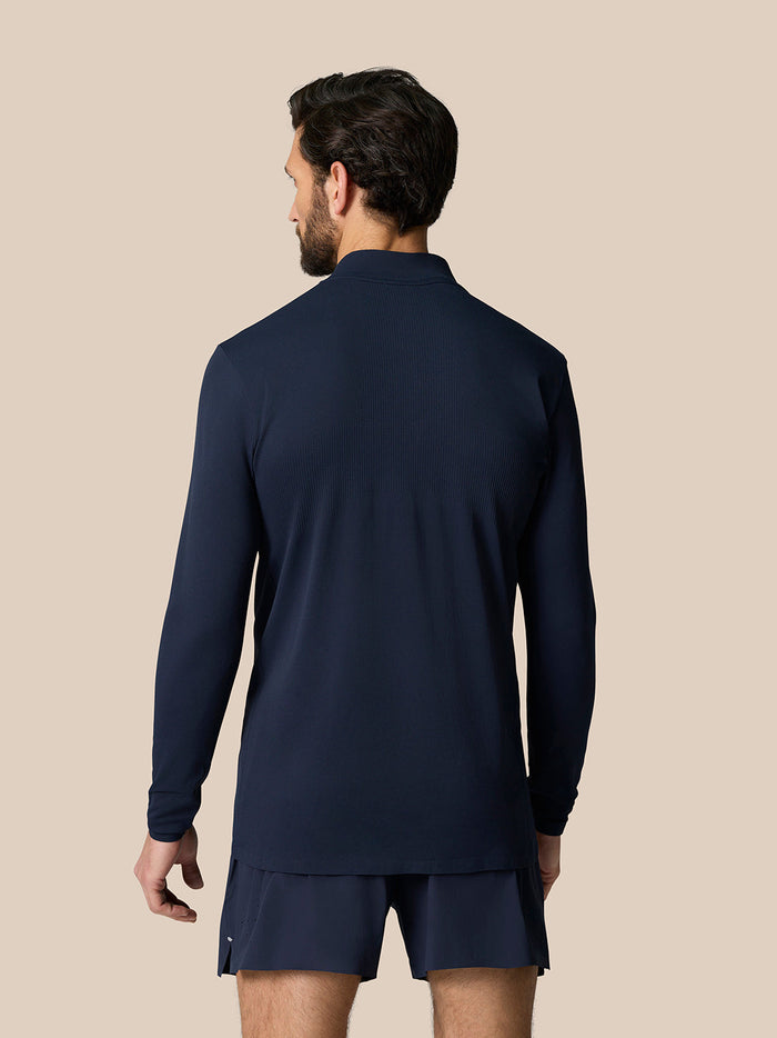 Back view of a model wearing the Zone Training 1/4 Zip Top in midnight navy, featuring a dropped hem and ribbed back panel.